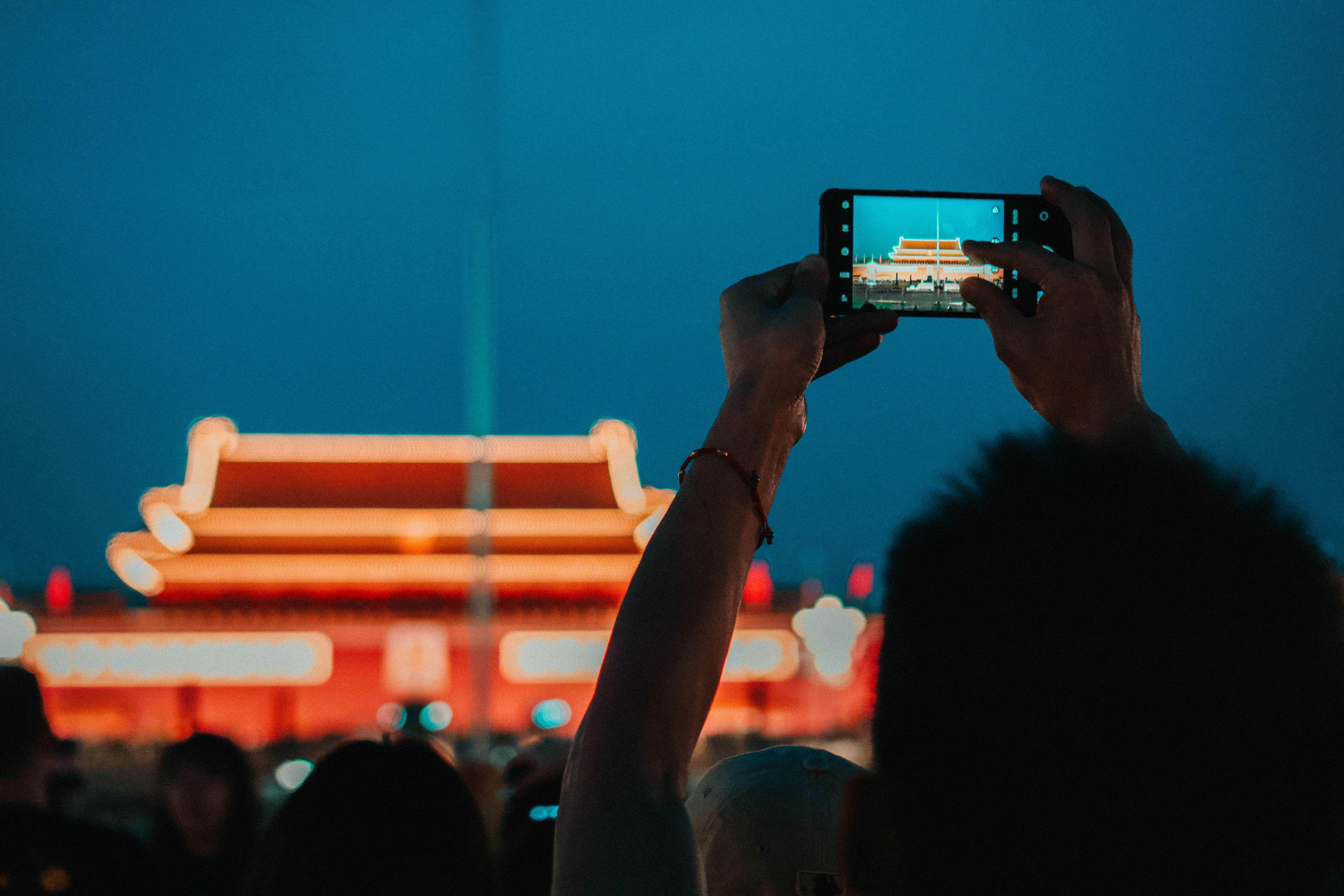 a person taking a picture of a building at night, Person taking photo in front of Mausoleum of Mao Zedong at Tiananmen Square in Beijing, Peking, China