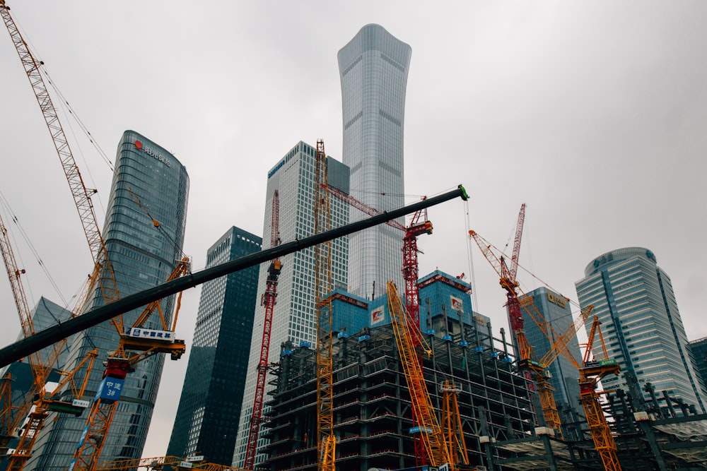 a large group of cranes standing in front of a tall building