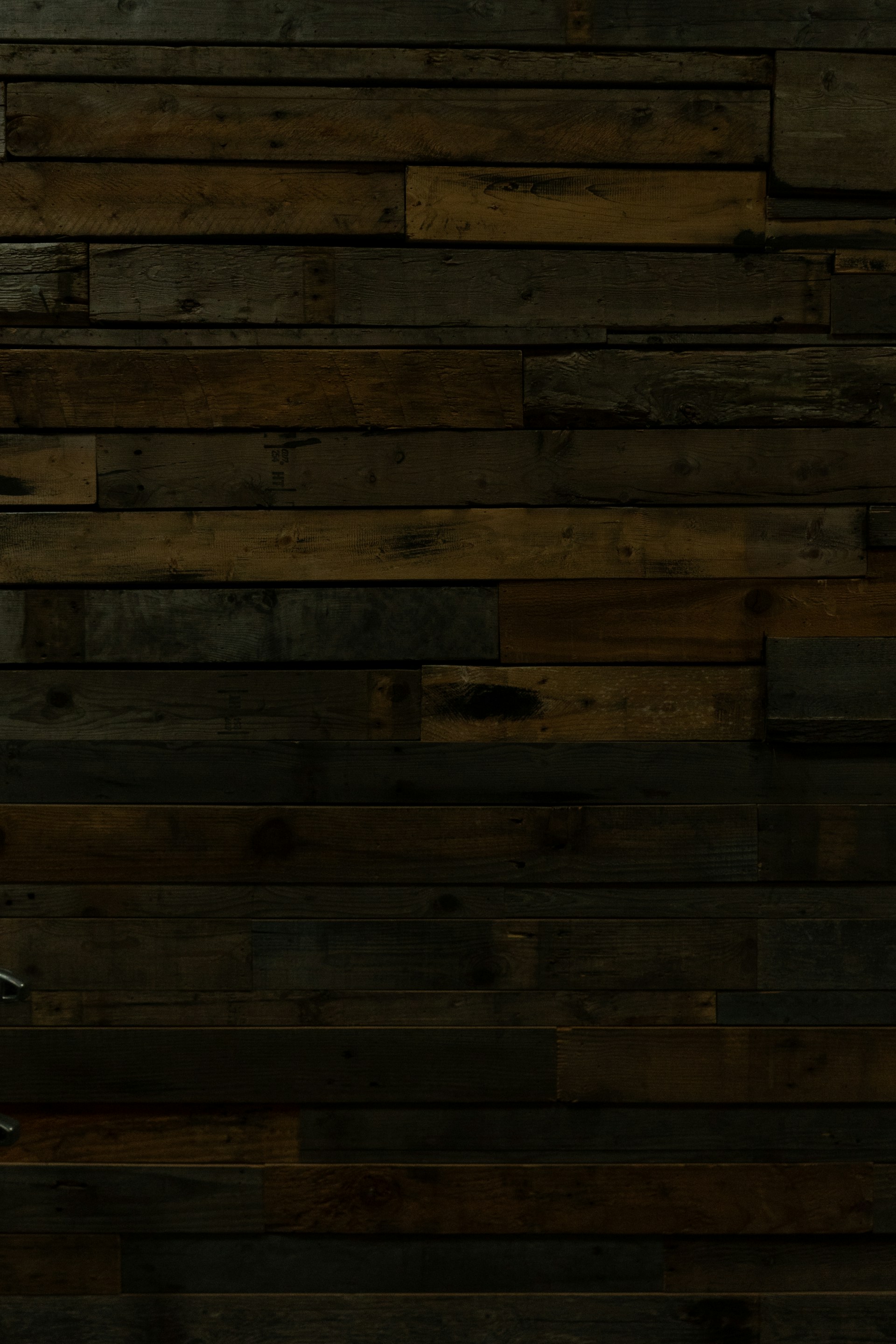 a man in a suit and tie standing in front of a wooden wall
