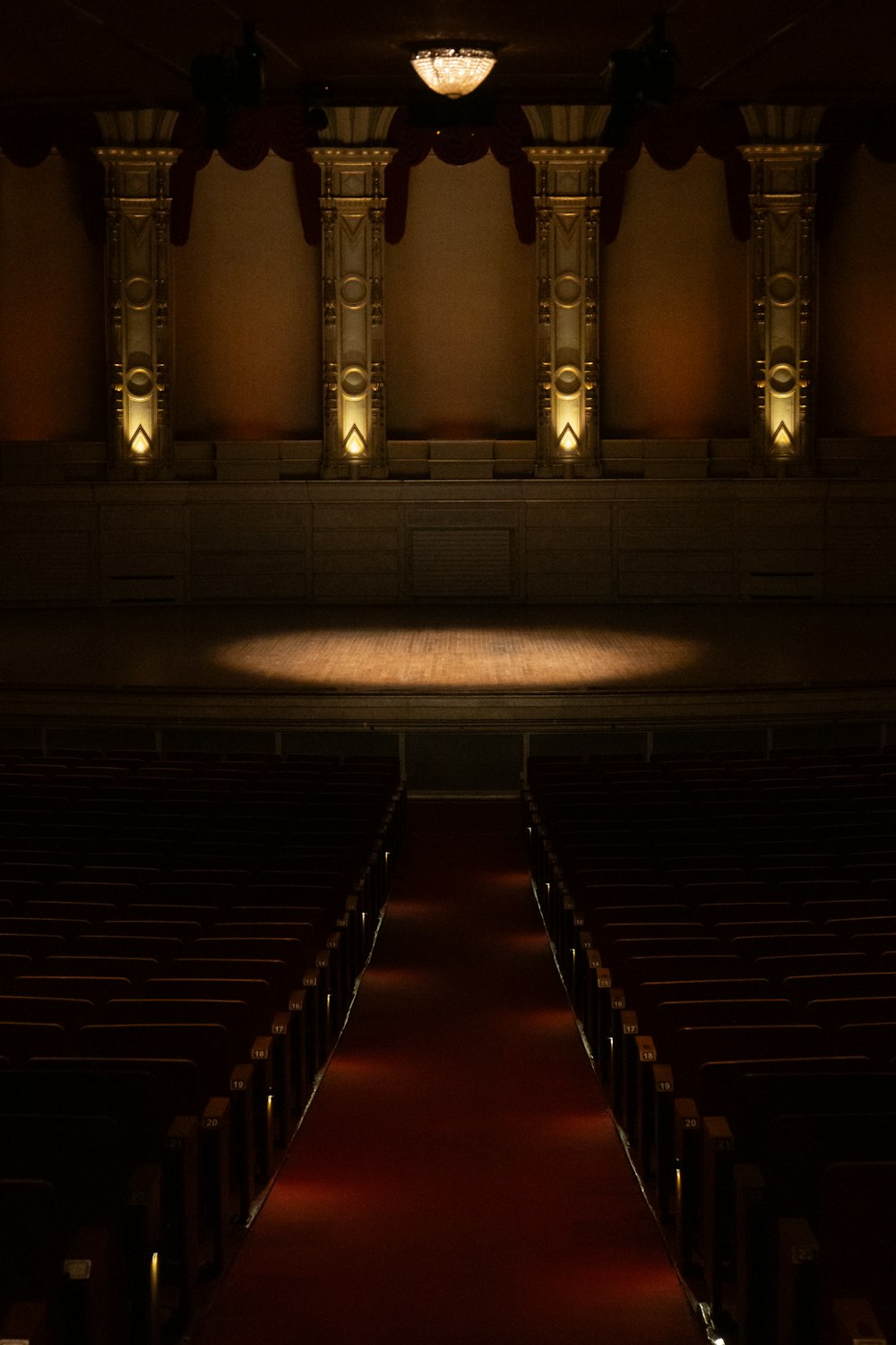 an empty auditorium with a red carpet and lights