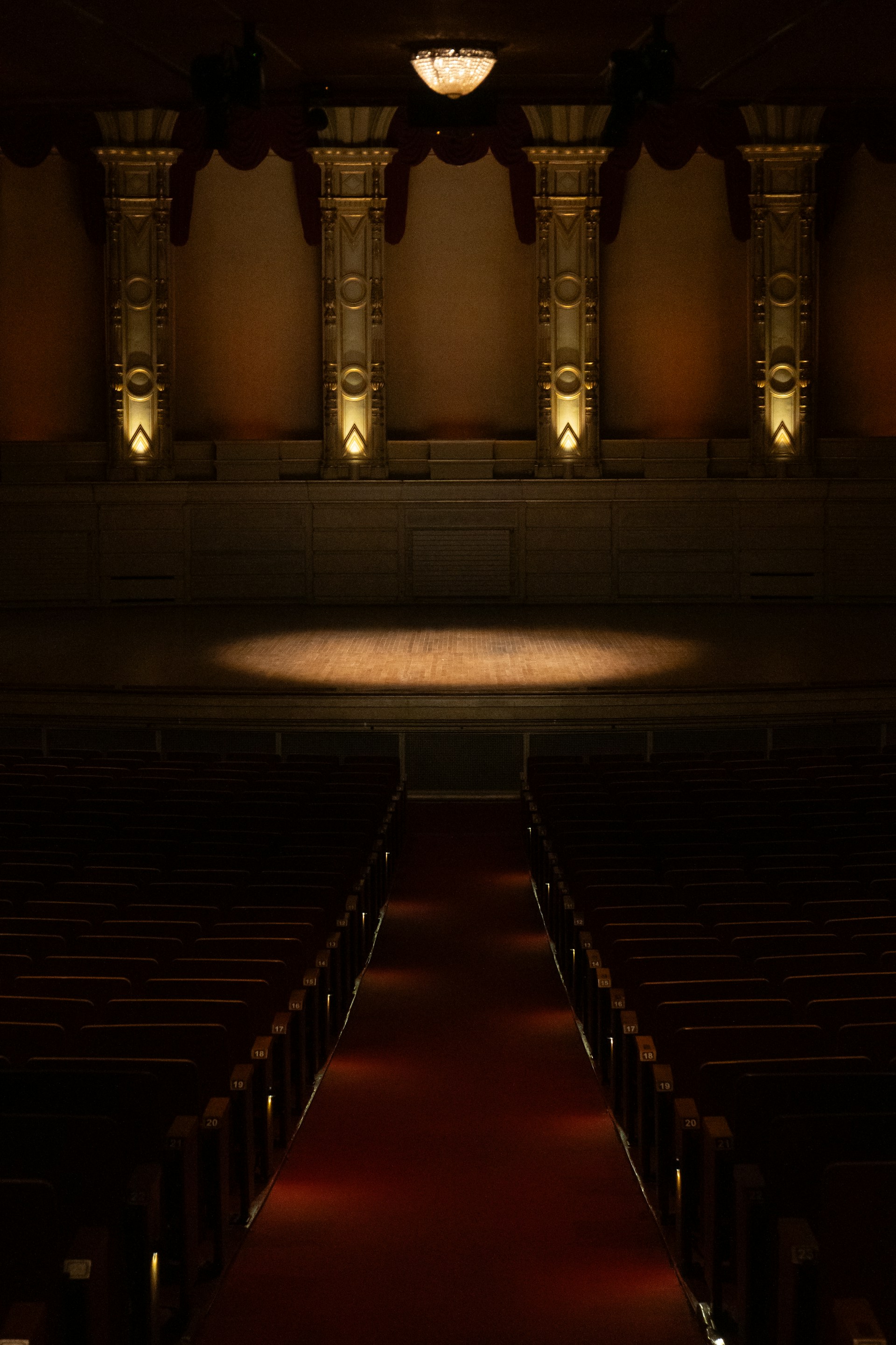 an empty auditorium with a red carpet and lights