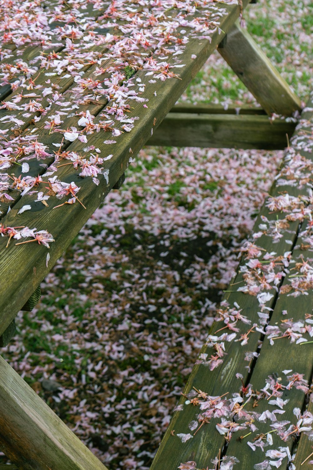 a wooden picnic table covered in pink and white flowers