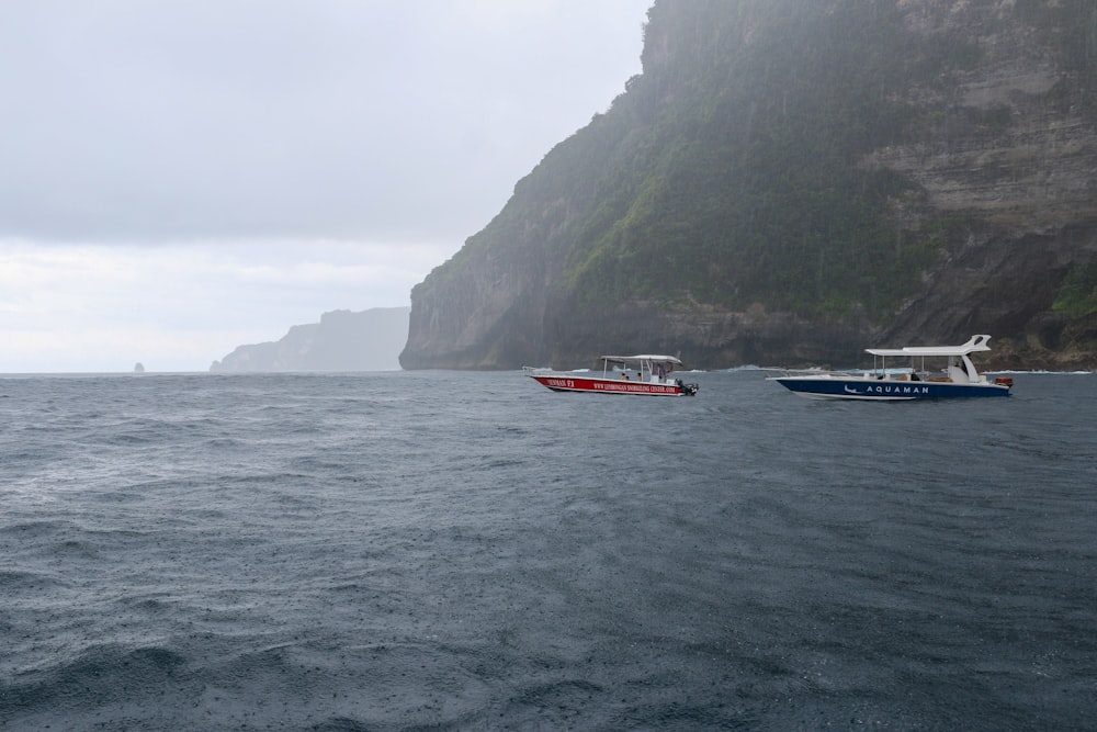 a couple of boats floating on top of a large body of water