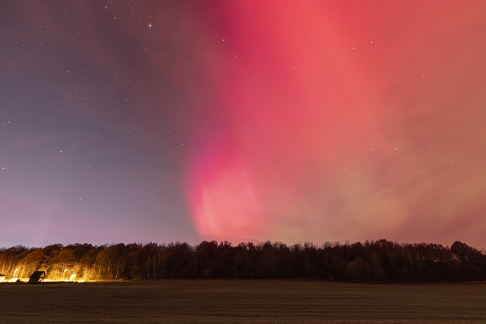 a bright pink and green aurora bore is in the sky