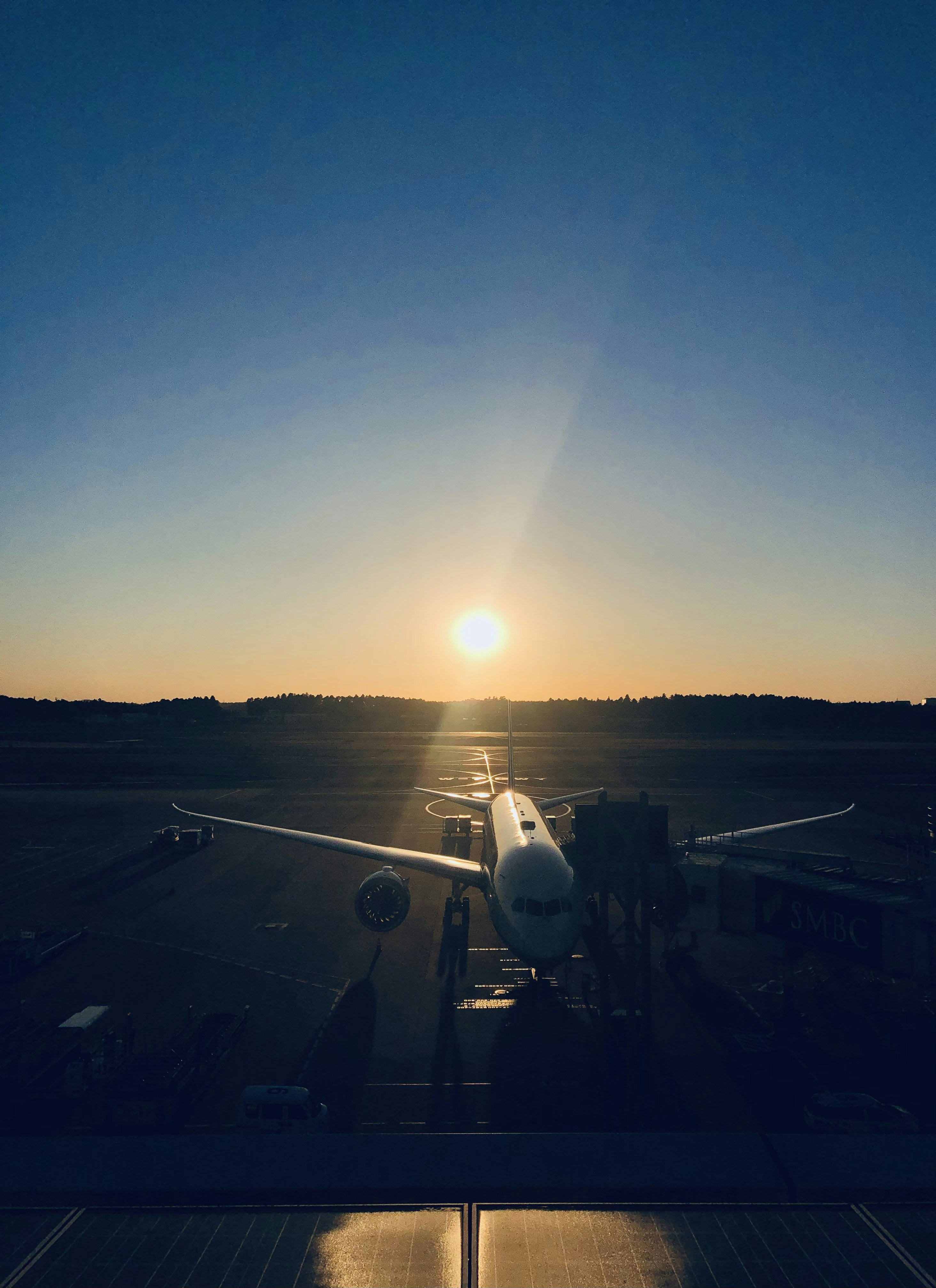 a plane is parked on the runway at sunset