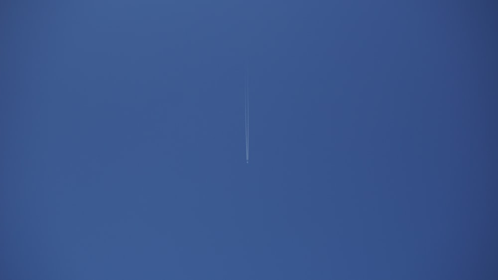 an airplane is flying in the blue sky