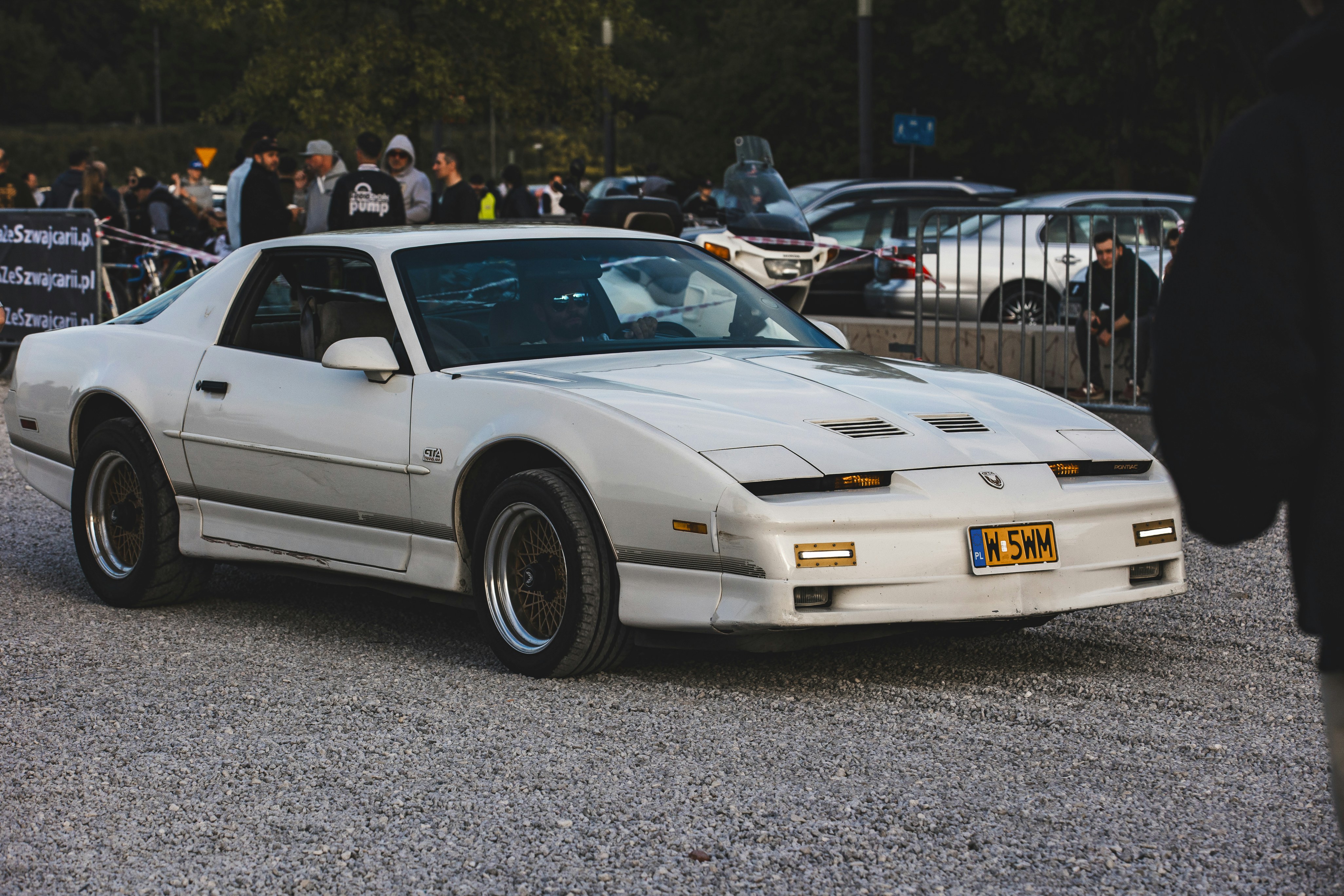 a white sports car parked in a parking lot