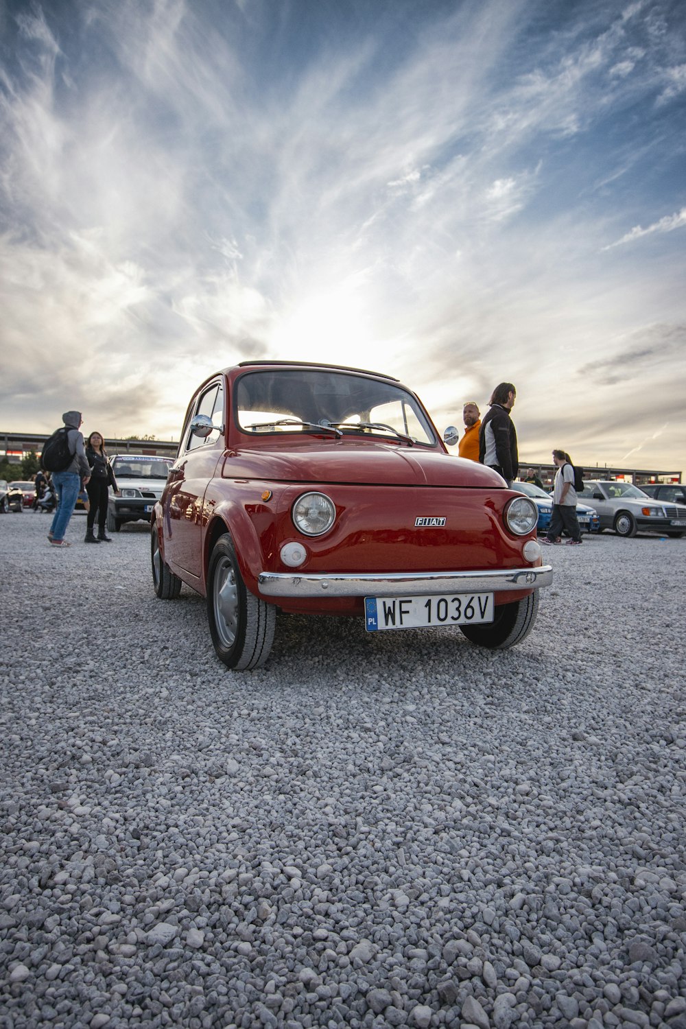 a small red car parked in a parking lot