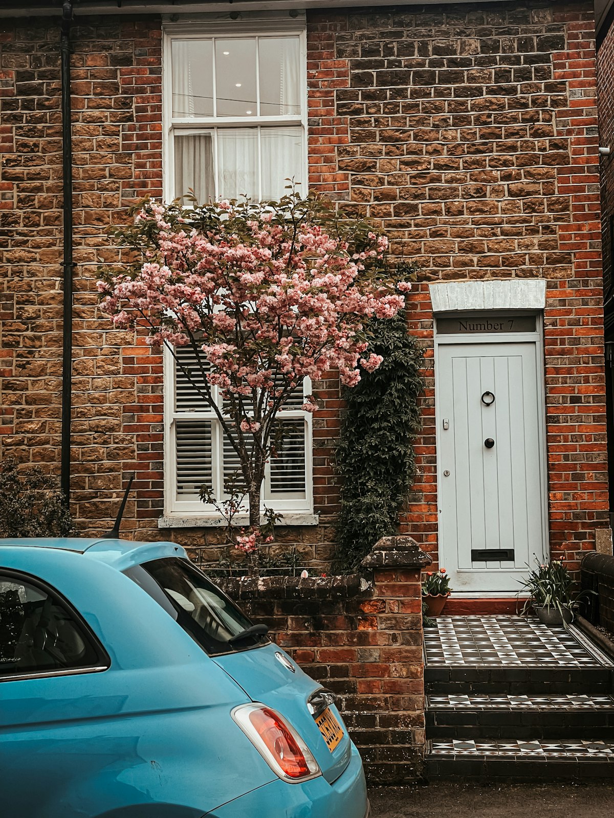 A brick house with spring cherry blossom on a street in Godalming, Waverley, Surrey