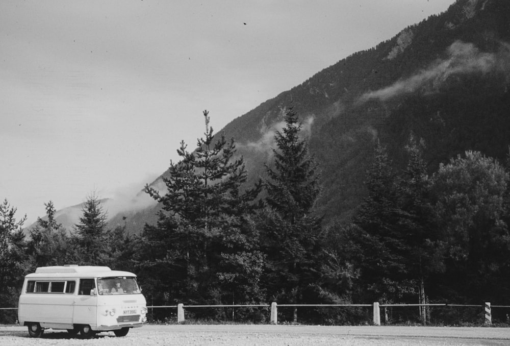a van parked on the side of a road in front of a mountain