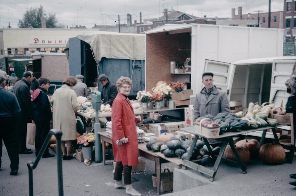 a woman standing in front of a table filled with vegetables