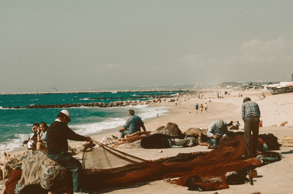 a group of people standing on top of a sandy beach