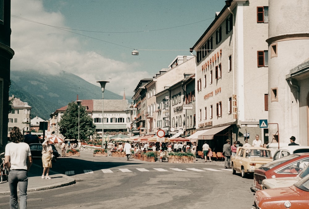 a man walking down a street next to tall buildings