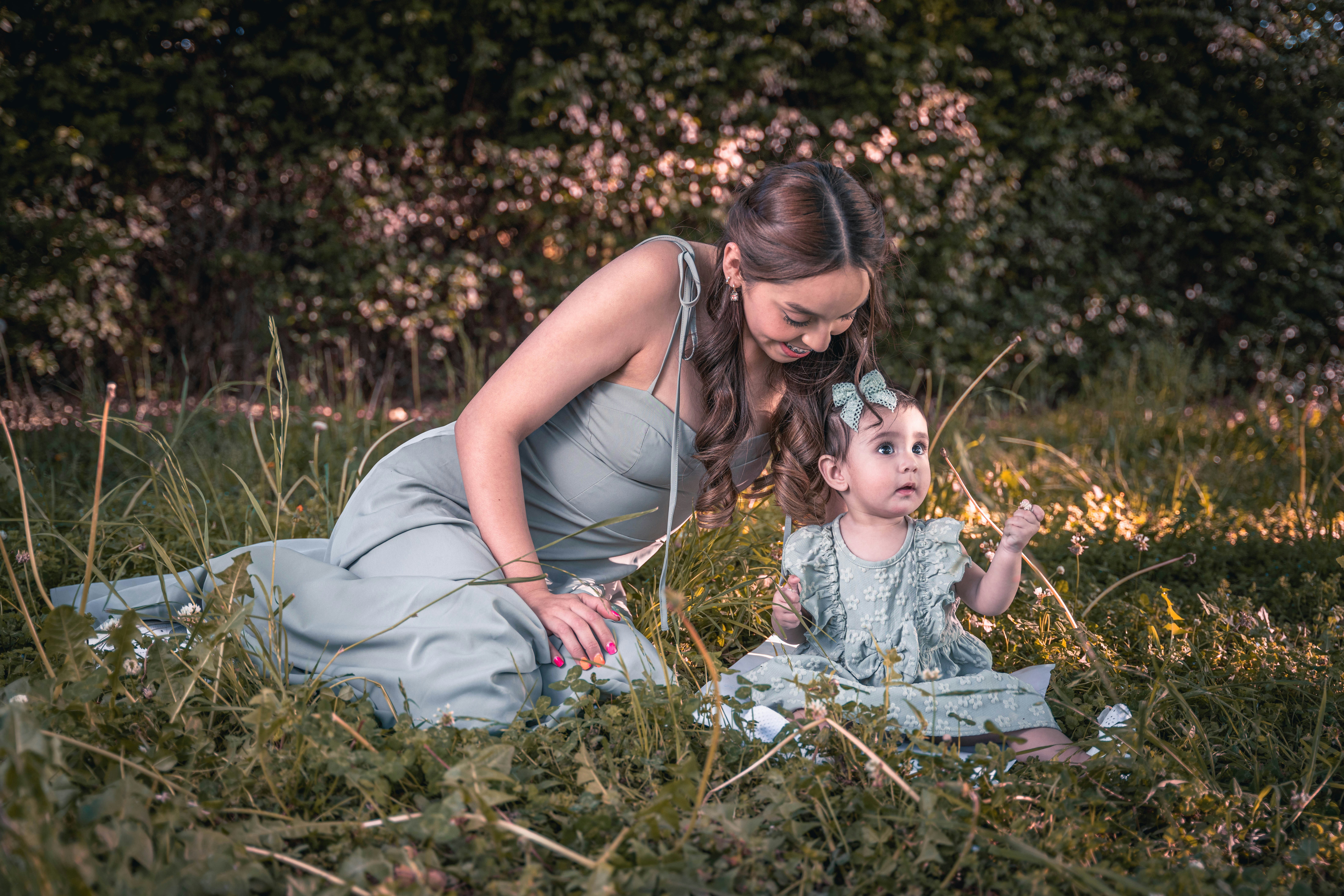 a woman and a child sitting in the grass