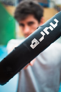 a man holding a black bat with white letters on it