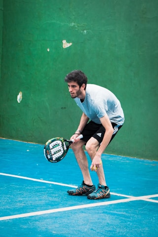 a man holding a tennis racquet on a tennis court