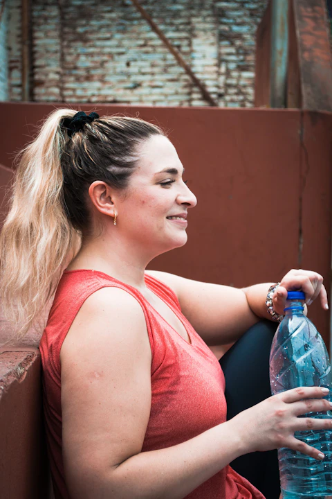 a woman with a ponytail holding a water bottle