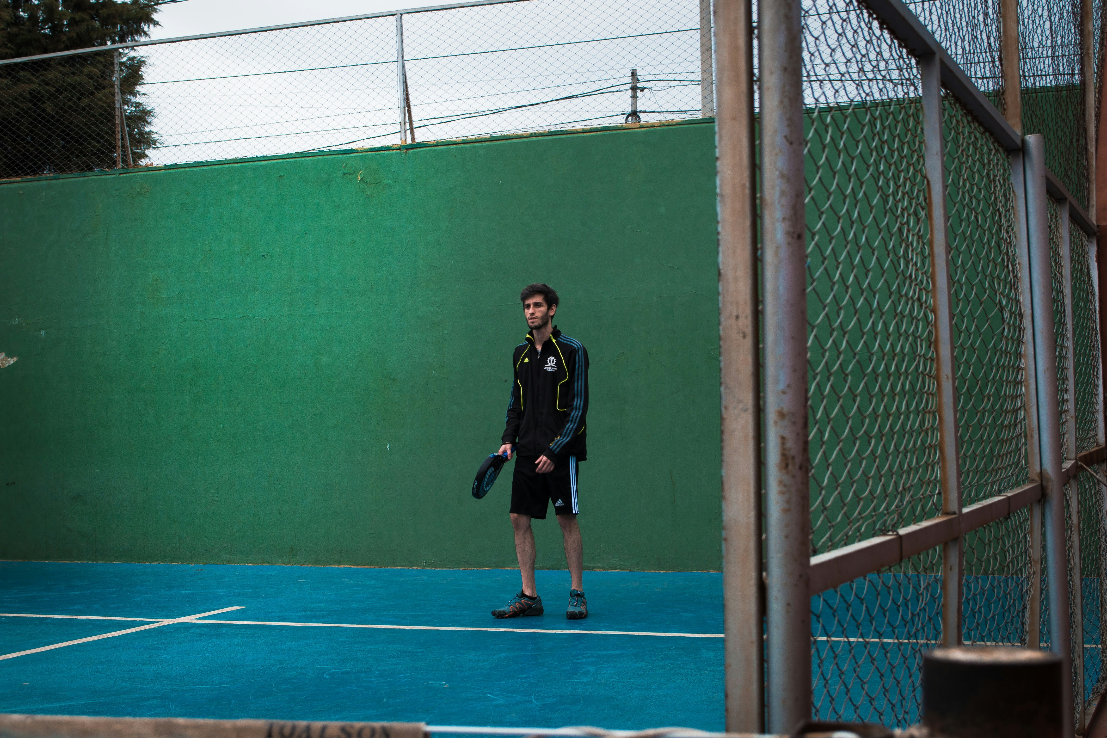 a man standing on a tennis court holding a racquet
