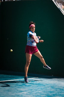 a woman swinging a tennis racquet at a tennis ball