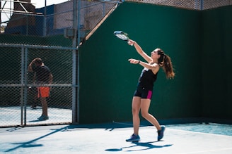 a woman holding a tennis racquet on a tennis court