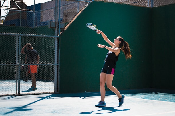 a woman holding a tennis racquet on a tennis court