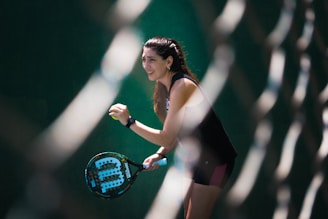 a woman holding a tennis racquet on a tennis court