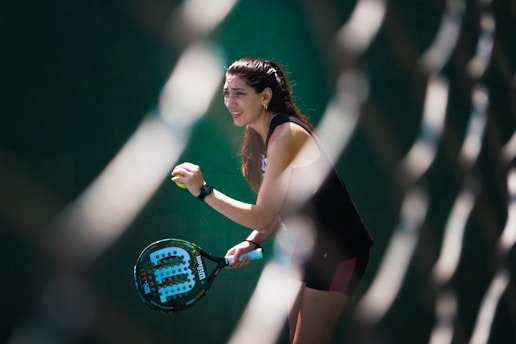a woman holding a tennis racquet on a tennis court