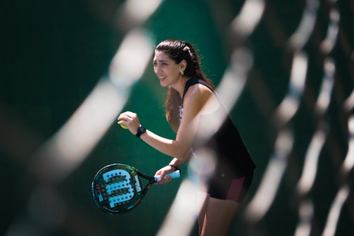 a woman holding a tennis racquet on a tennis court