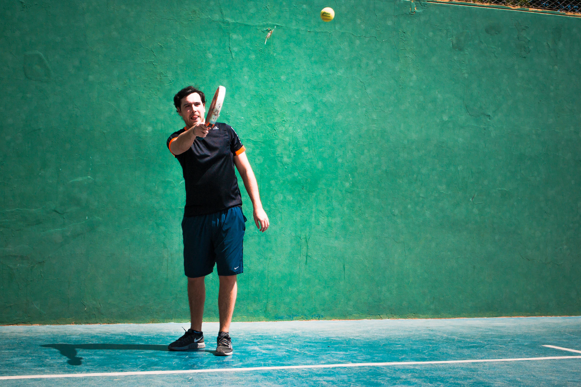 a man standing on a tennis court holding a racquet
