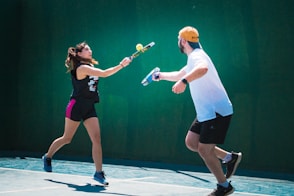 a man and a woman playing tennis on a tennis court