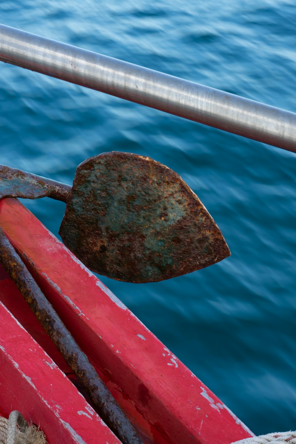 a rusted piece of metal sitting on top of a red boat