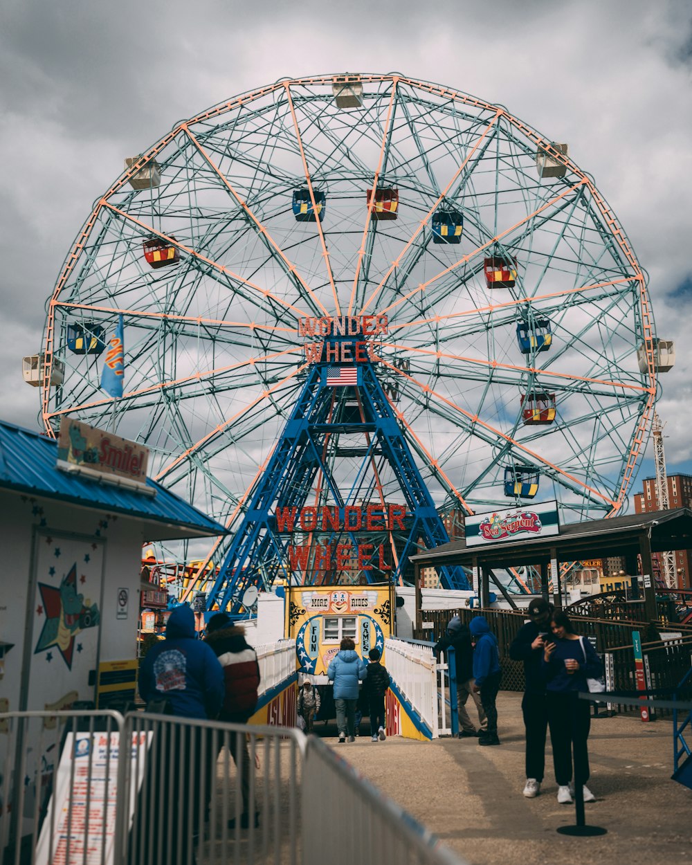 a ferris wheel with people standing around it