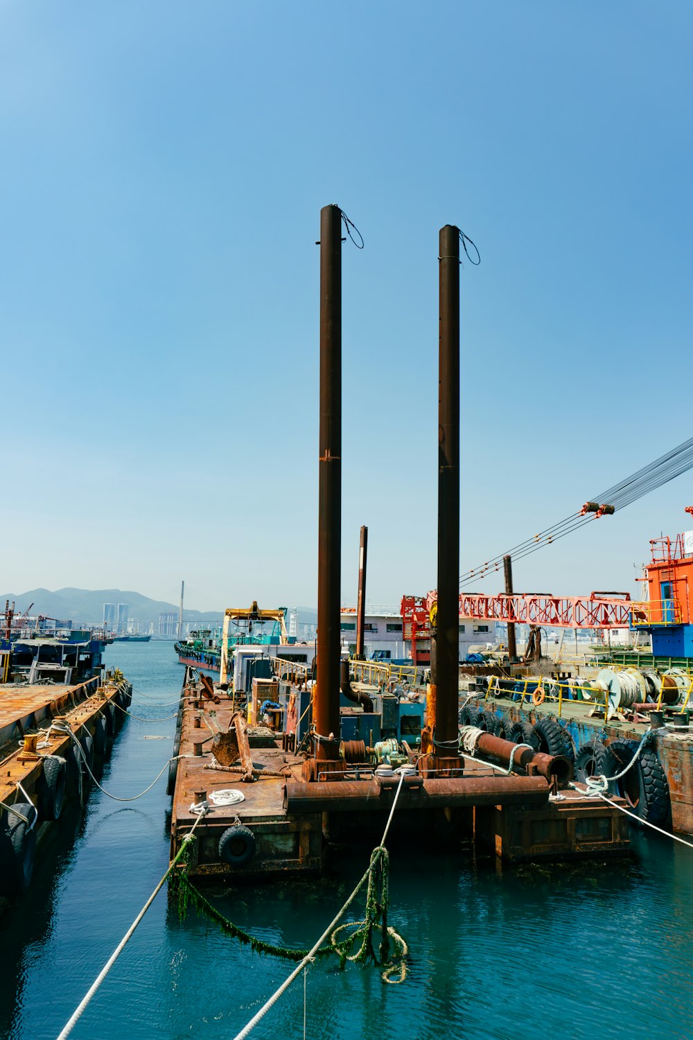 a dock with a few boats and a crane in the background