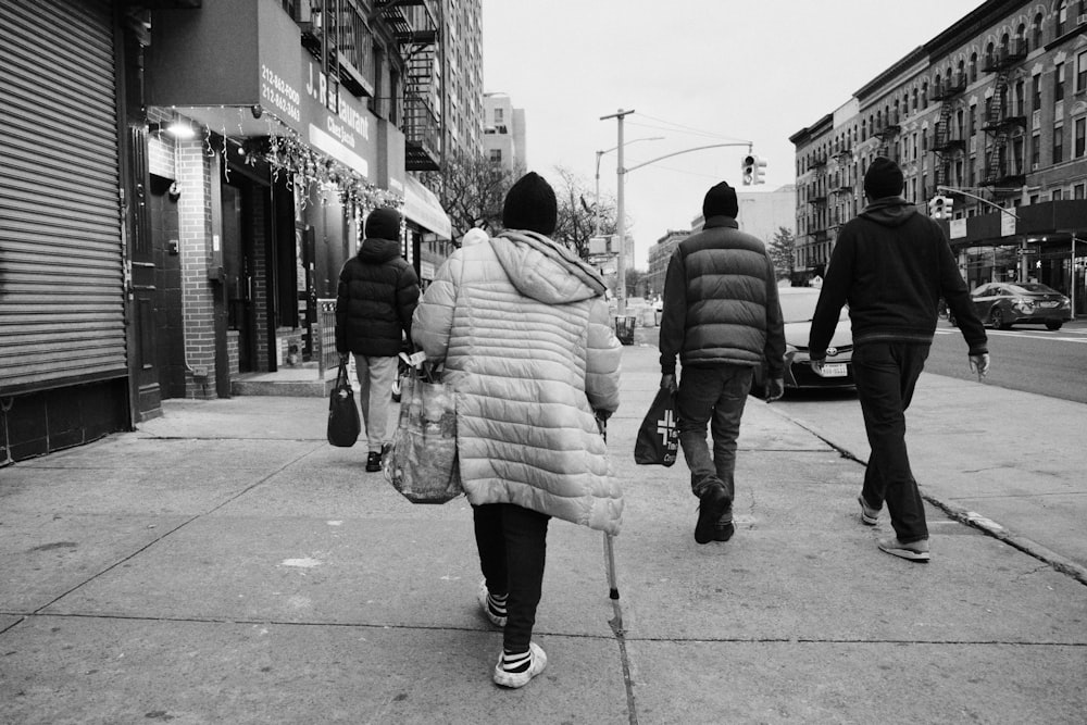 a group of people walking down a sidewalk
