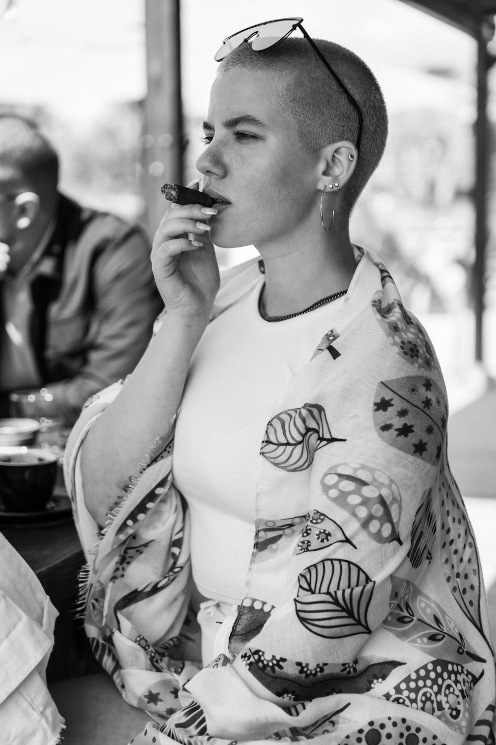 a woman with a shaved head eating a donut
