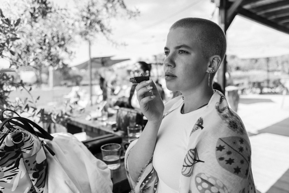 a black and white photo of a woman with tattoos on her arms