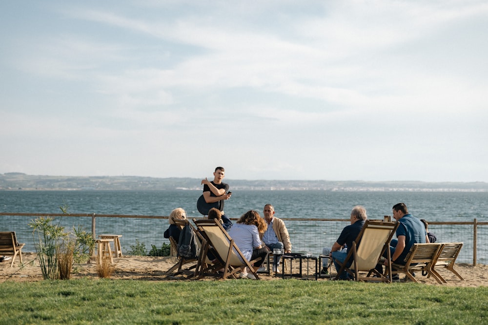 a group of people sitting around a table on the beach