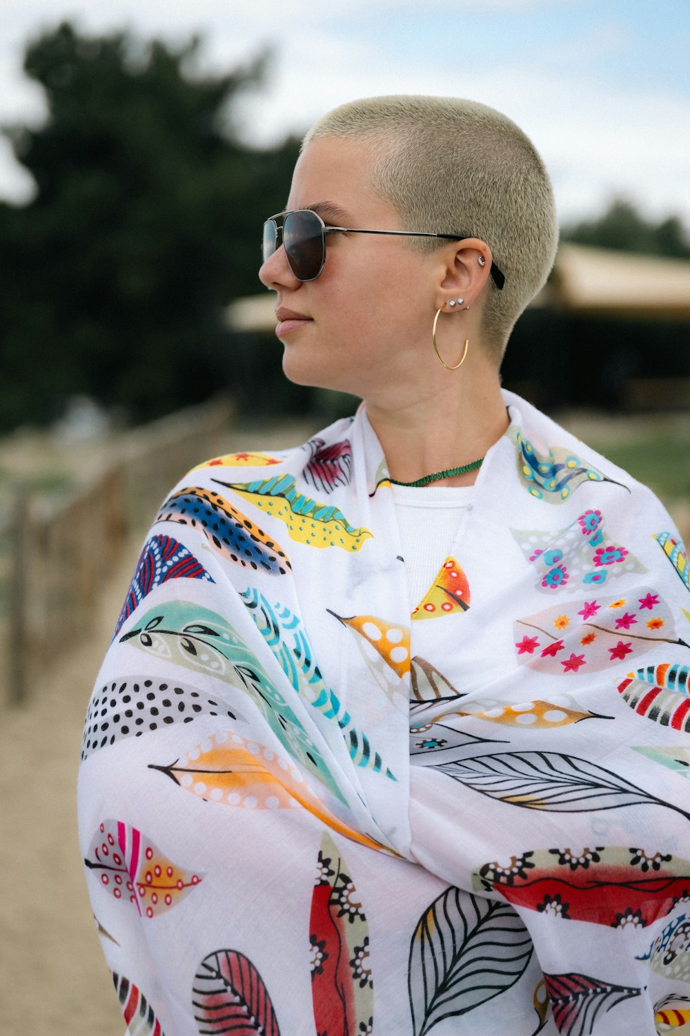 a woman with a shaved head wrapped in a blanket