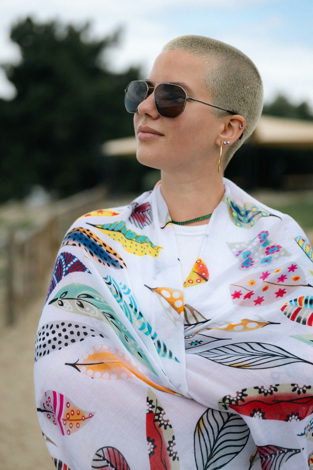 a woman with a shaved head wearing sunglasses