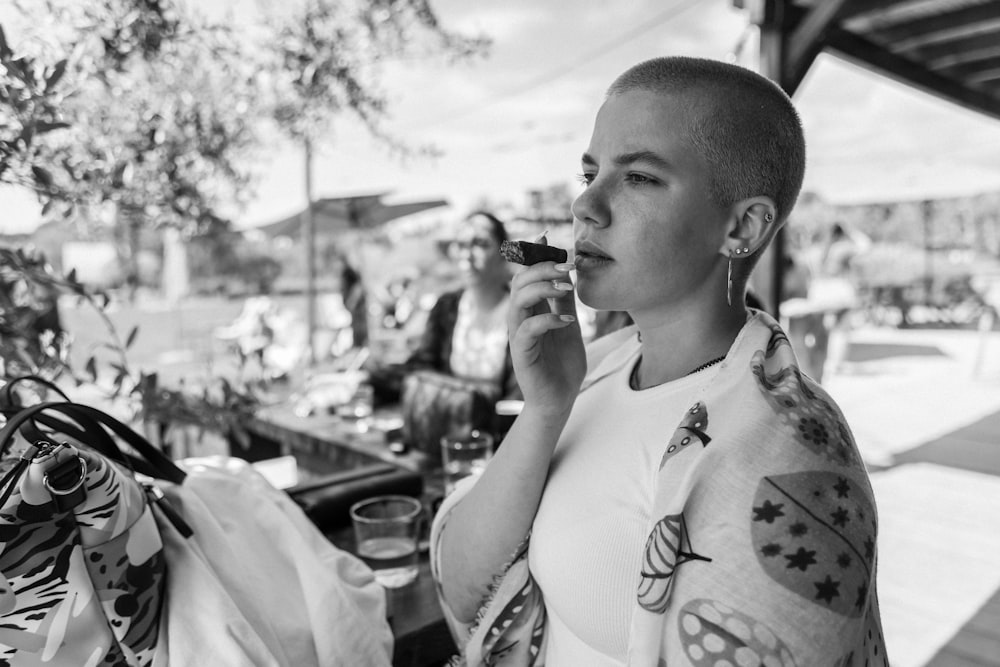 a woman with tattoos on her arm talking on a cell phone