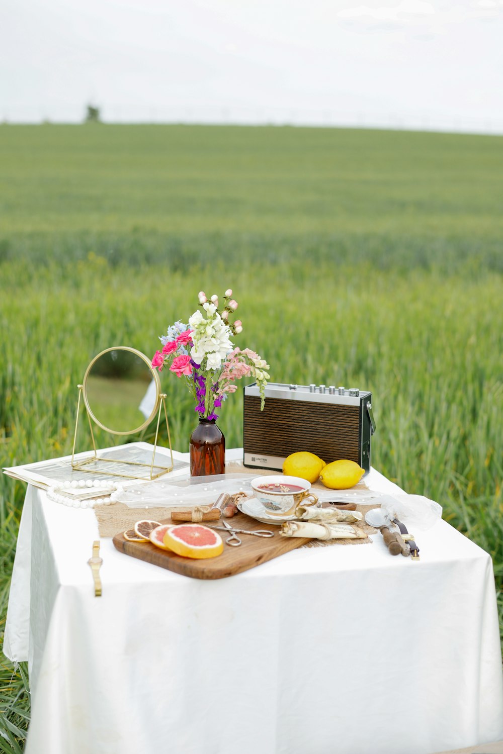 a picnic table in a field with flowers and fruit