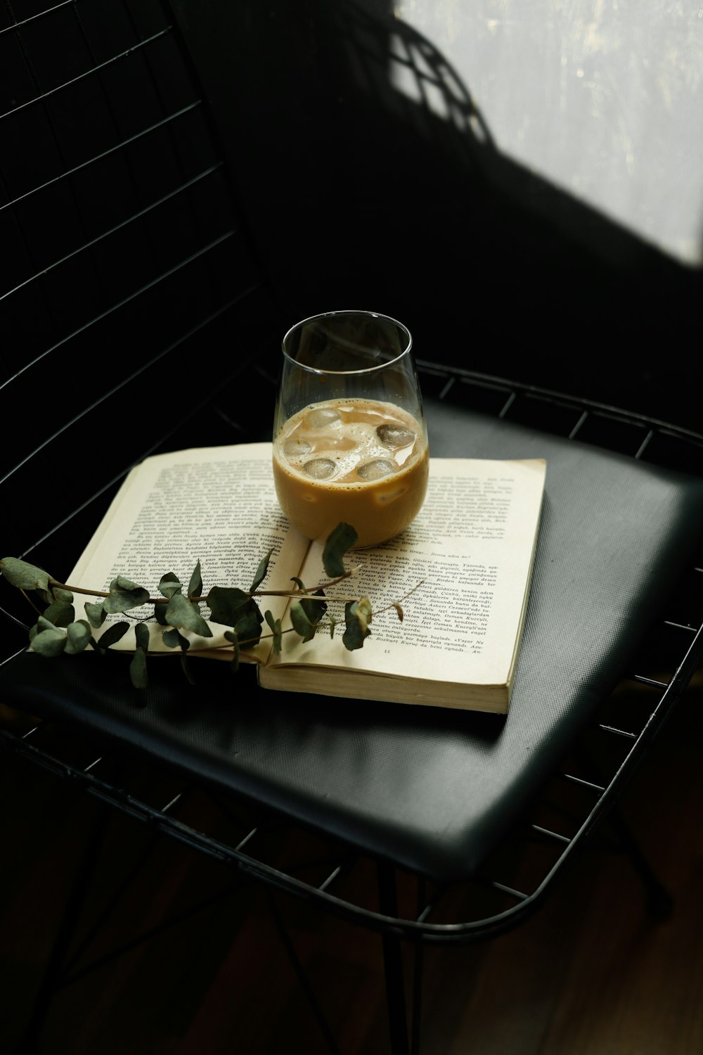 a glass of liquid sitting on top of an open book