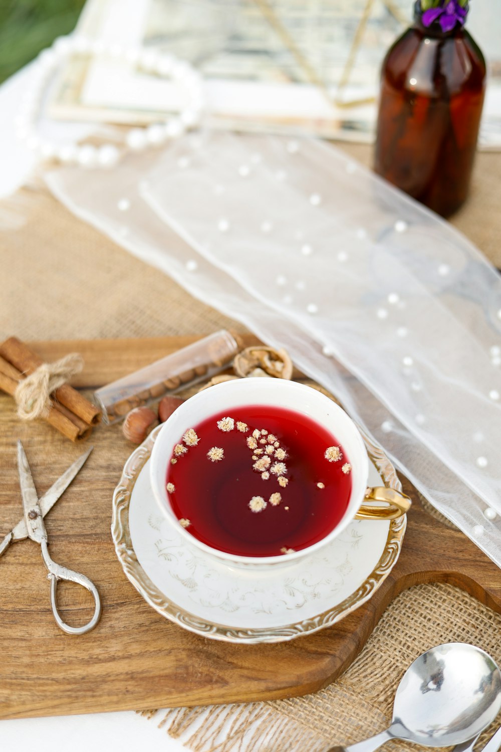 a bowl of red liquid sitting on top of a wooden table
