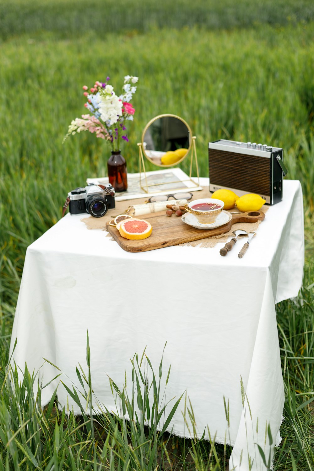 a picnic table with food on it in the middle of a field
