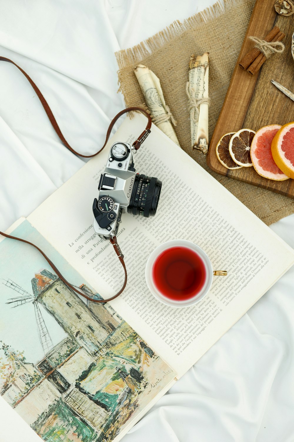 a camera and a cup of tea on a bed