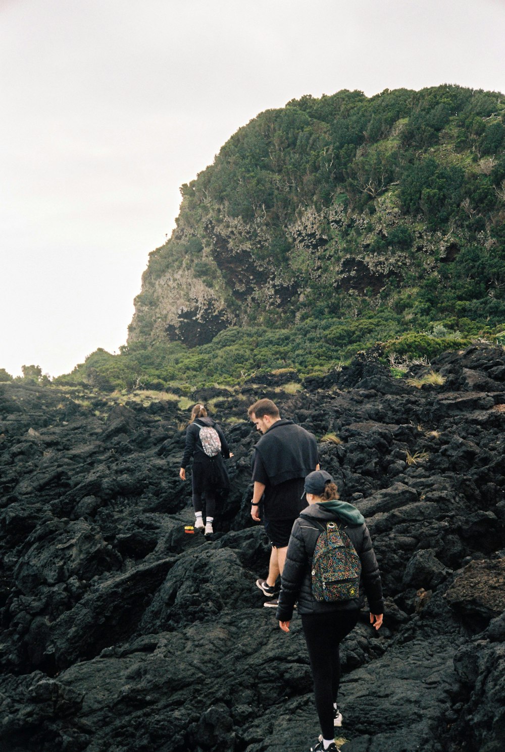 un gruppo di persone che camminano su una collina rocciosa