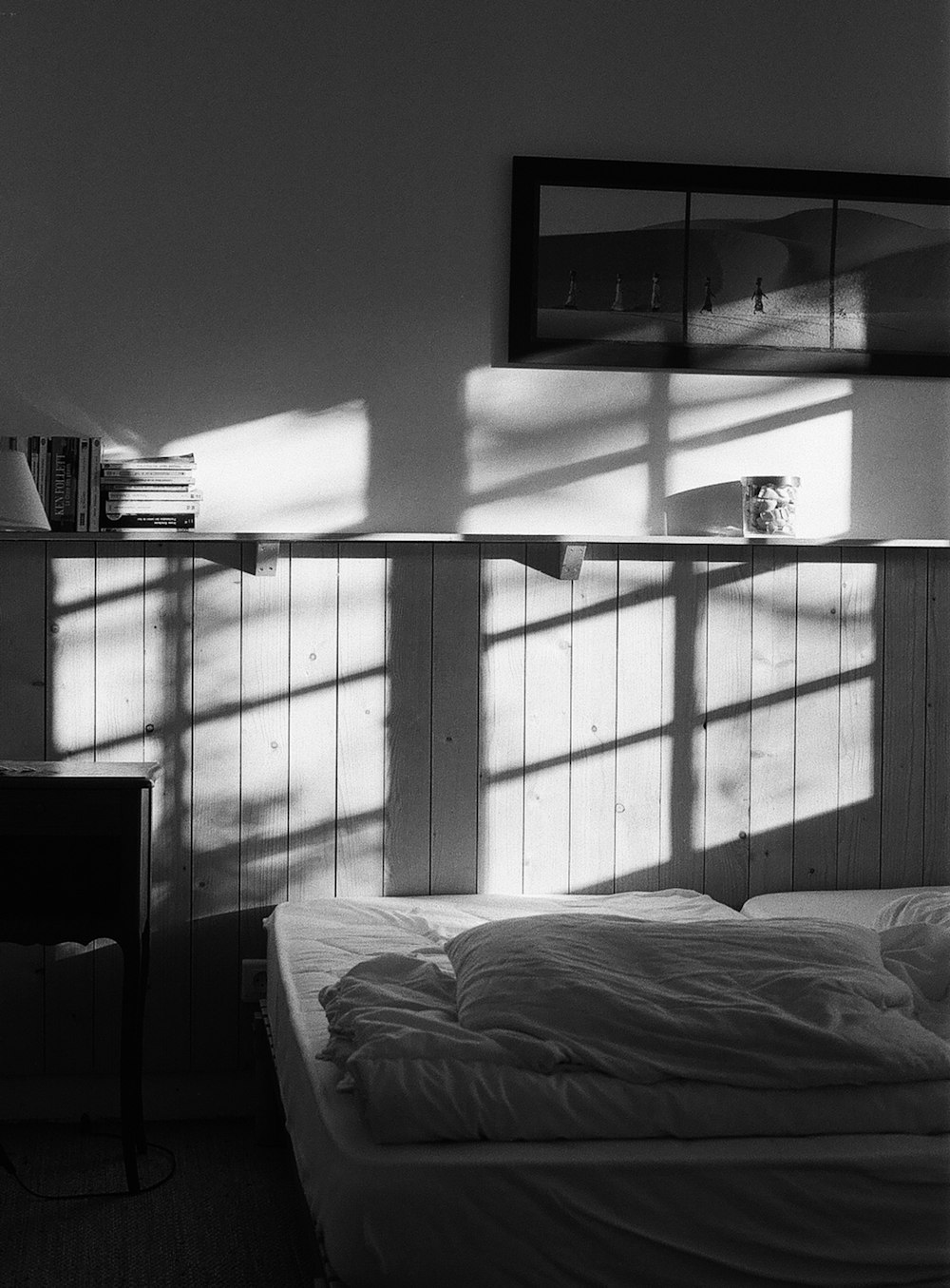 a black and white photo of a bed in a bedroom