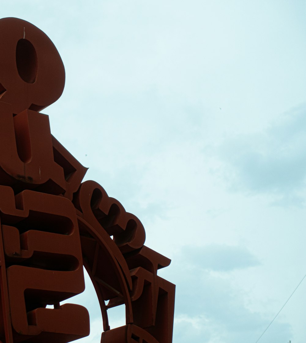 a close up of a sign with a sky in the background