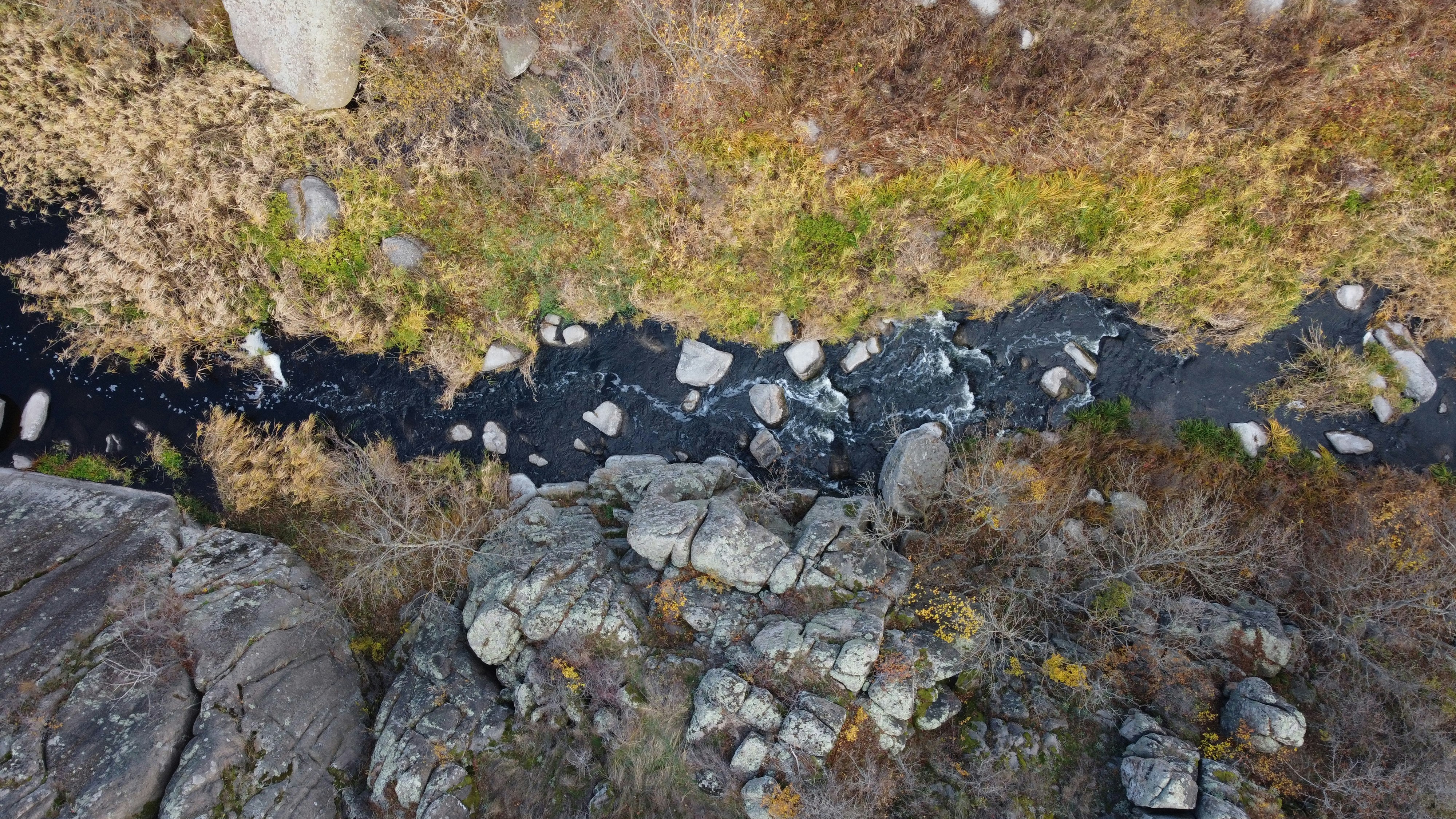 an aerial view of a river running through a rocky area