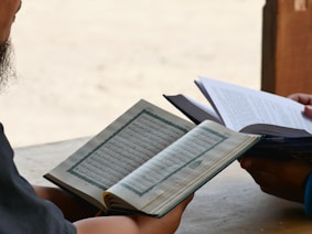 a man sitting at a table reading a book